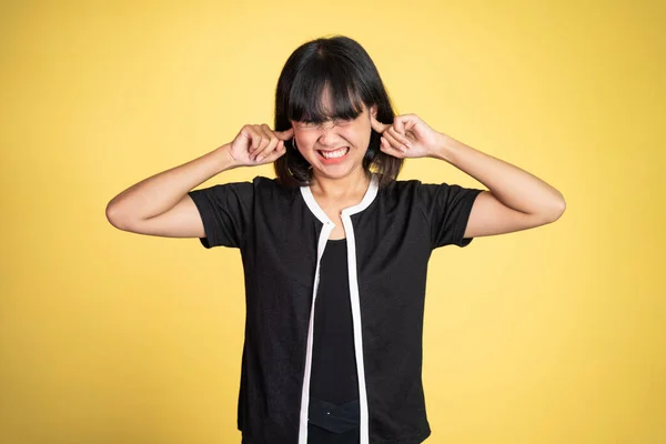 Woman with annoyed expression covering ears with both hands — Stok fotoğraf