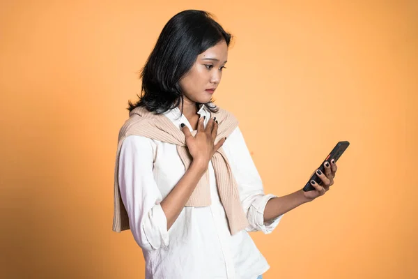 Triste asiático jovem mulher ao usar o telefone móvel — Fotografia de Stock