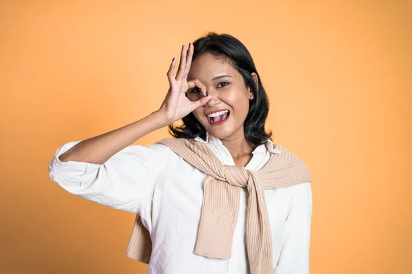 Woman showing oke gesture with hands near eye looks imitating binocular — 스톡 사진