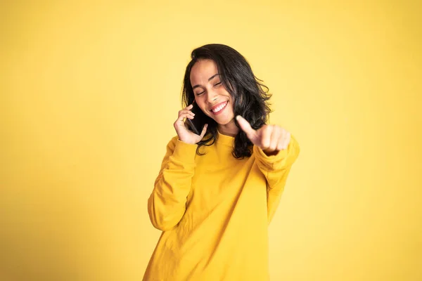 Junge Frau benutzt Handy mit erhobenem Daumen — Stockfoto