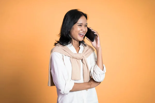 Mulher fazendo uma chamada usando um telefone celular em fundo isolado — Fotografia de Stock
