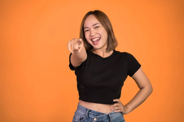 Woman with finger pointing at frong and laughing at something — Stockfoto