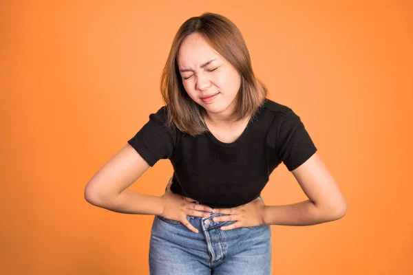 Woman having her period holding her stomach in pain — Foto Stock