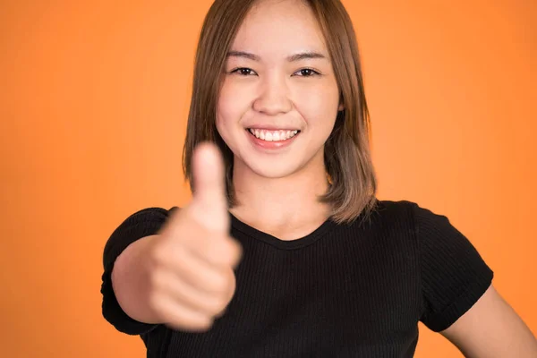Woman stand with thumbs up on isolated background — ストック写真