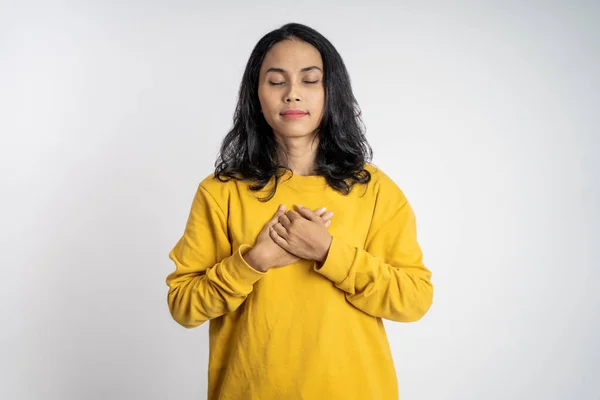 Asiático jovem mulher segurando peito enquanto se sente aliviado — Fotografia de Stock