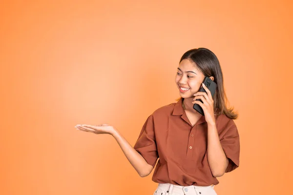Woman hold a mobile phone with hand gesture presenting — Stockfoto