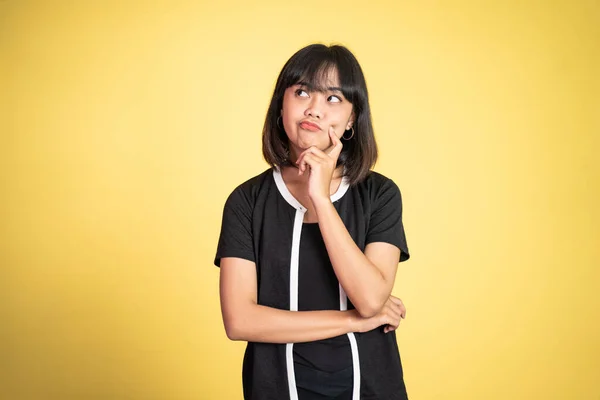 Bedachtzame Aziatische vrouw stelt tegen geïsoleerde achtergrond — Stockfoto