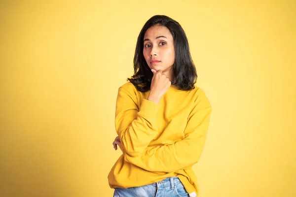 Beautiful woman on isolated background with thoughtful expression — Stockfoto