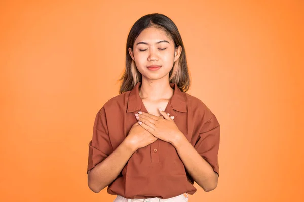 Azji młoda kobieta trzyma klatkę piersiową podczas uczucie ulgi — Zdjęcie stockowe