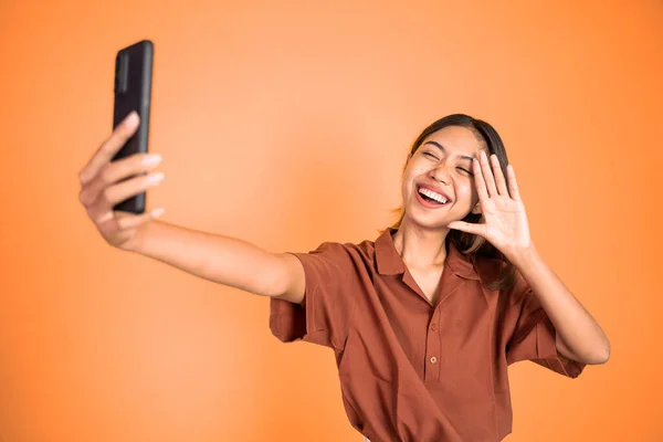 Woman make a video call using mobile phone with saying hello gesture — Foto Stock