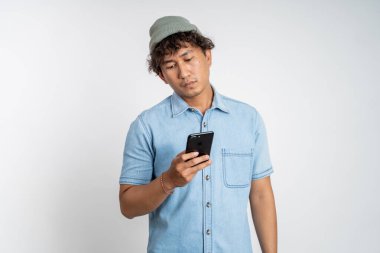 Akıllı telefonuna tek başına bakarken genç adamın kafasını karıştır.