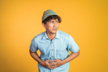 Arka planda karnı ağrıyan bir adam.