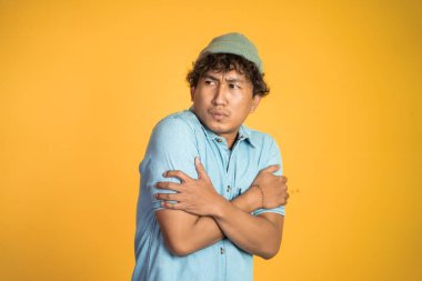 Adam iki kolunu birden tutarken titriyor.