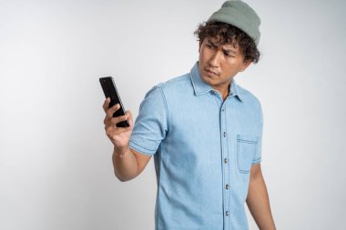 Akıllı telefonuna tek başına bakarken genç adamın kafasını karıştır.