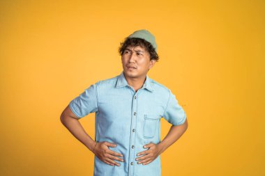 Arka planda karnı ağrıyan bir adam.