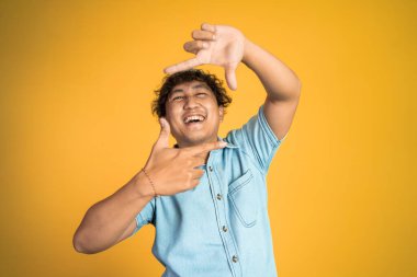 Parmağını kullanarak çerçeveyi şekillendiren jestli bir adam.