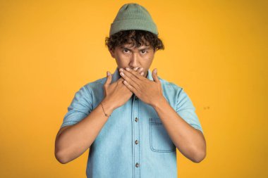 Ağzı kapalı bir adam izole edilmiş arka planda duruyor.