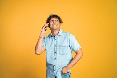 Adam gülerken arka planda telefon görüşmesi yapıyor.