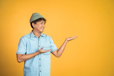 El hareketleriyle Asyalı bir adam bir şey sunuyor.