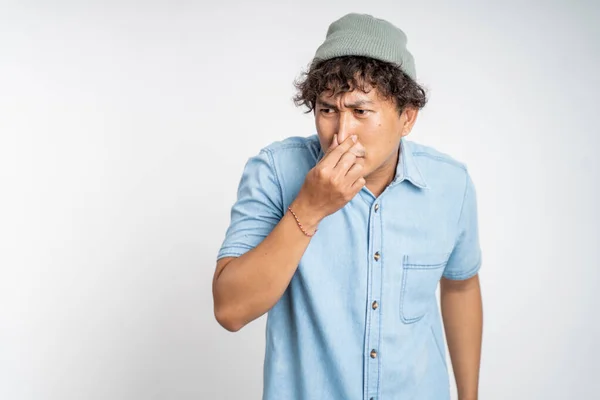 Znechucený asijský mladý muž zakrývající nos s rukama — Stock fotografie