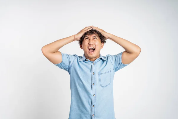 Zestresowany azjatycki młody człowiek trzyma jego głowa — Zdjęcie stockowe