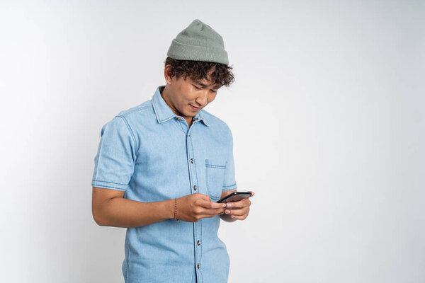 asian young man looking at the screen of a mobile phone