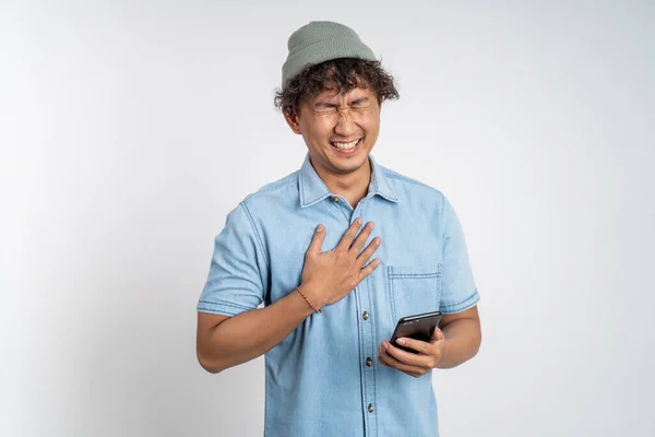 Νεαρός άνδρας γελάει σκληρά όταν κοιτάζει ένα κινητό τηλέφωνο — Φωτογραφία Αρχείου