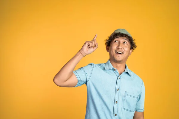 Sonriente hombre con el dedo apuntando hacia arriba en el fondo aislado — Foto de Stock