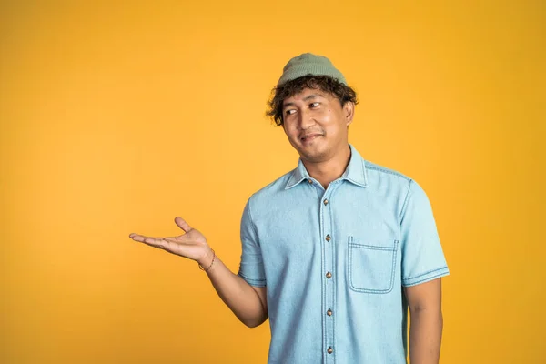 Asiático homem sorrindo com ambas as mãos apresentando algo — Fotografia de Stock