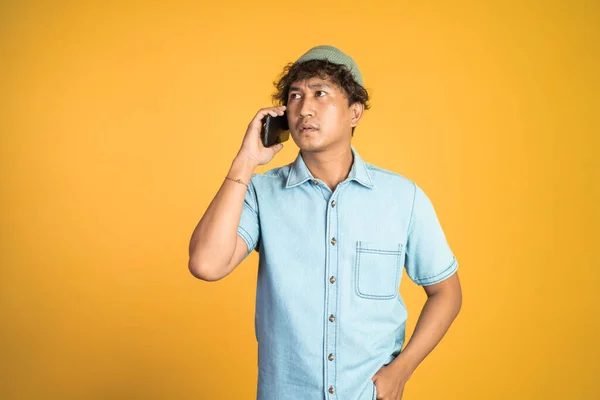 Asian man shocked while talking on his smartphone — Stock Photo, Image