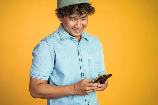 Asian young man looking at the screen of a mobile phone — Stock Photo, Image