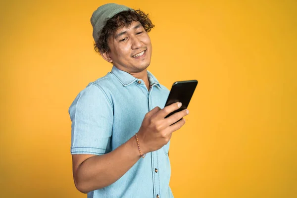 Asian young man looking at the screen of a mobile phone — Stock Photo, Image