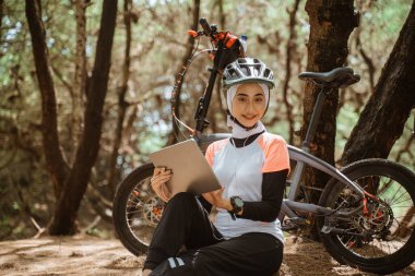 Otururken dijital tablet kullanan çekici peçeli kadın