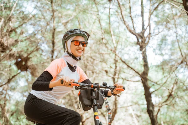 Parkta bisiklet süren güneş gözlüklü güzel Asyalı kız.