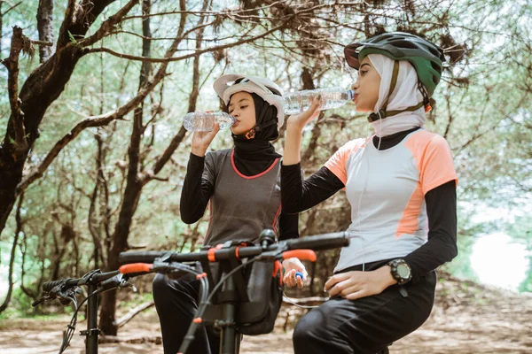 Dvě muslimské ženy pijící minerální vody láhve během přestávky — Stock fotografie
