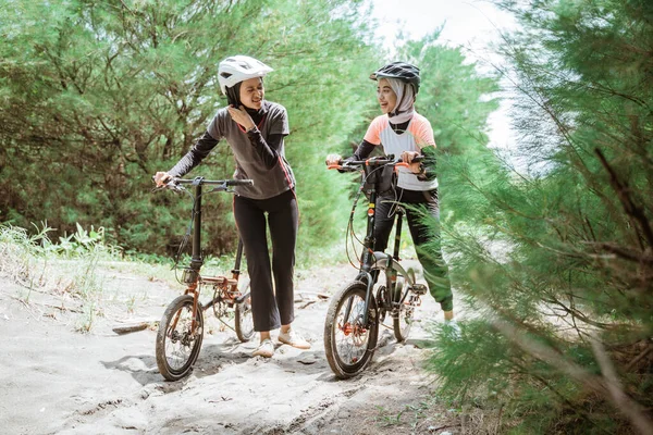 Dwóch muzułmańskich rowerzystów zmęczonych po przejściu przez piaszczystą drogę — Zdjęcie stockowe