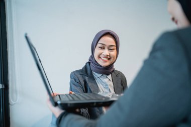 Müslüman kadın işçi sunumunu ofisteki ortağıyla yapıyor.