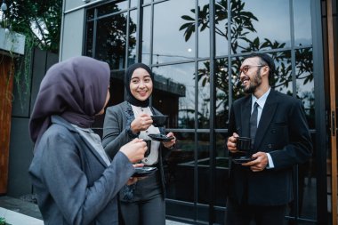 Asyalı iş adamları mesai arasında sohbet ediyorlar.
