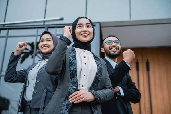 Businesswoman wearing hijab raise their arm showing success — Zdjęcie stockowe