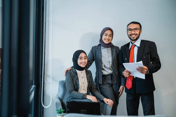 Businessman at meeting with his two female muslim employee — Stockfoto