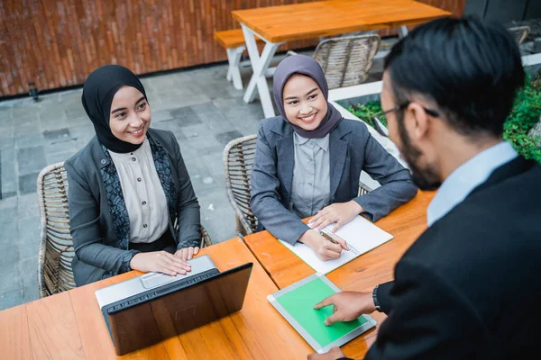 Businessman at meeting with his two female muslim employee — Photo