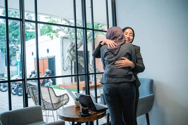 Мусульманский рабочий приветствует и обнимает своего партнера во время встречи в офисе — стоковое фото