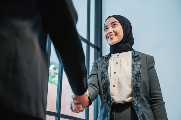 Muslim business woman shaking hand with partner at the office — стоковое фото