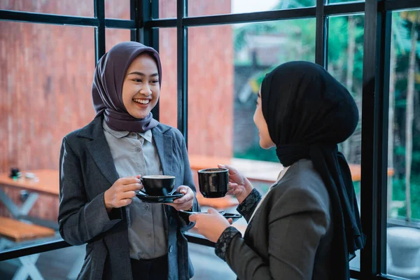 muslim business woman wearing hijab having a conversation together