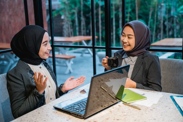 Азіатська мусульманка розмовляє, насолоджуючись кавою і працюючи — стокове фото