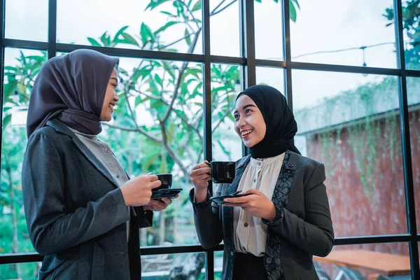 Müslüman işçiler kahve molasında ofiste sohbet ediyorlar.