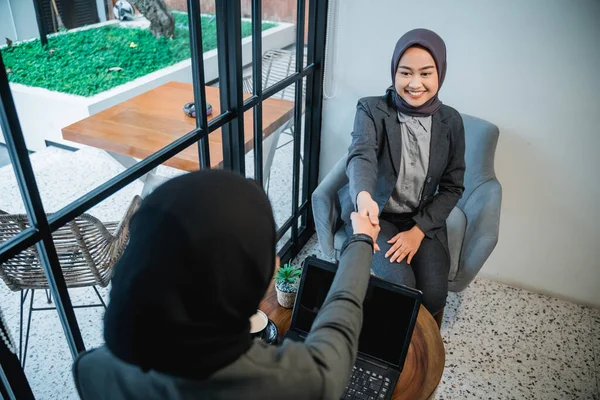 Woman shaking hand while having a break at the office — Stockfoto