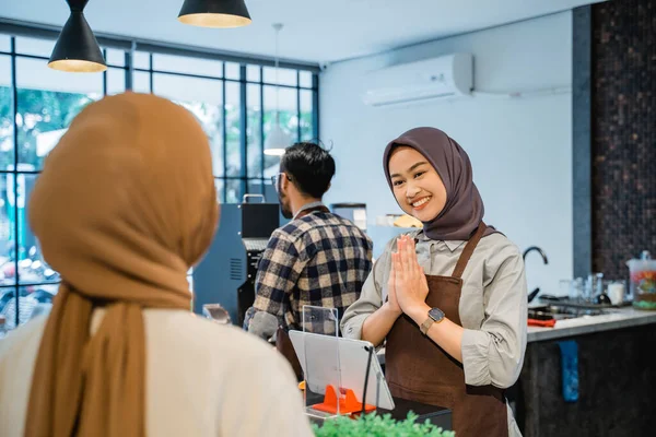 Ázsiai muszlim kávézó dolgozó üdvözlő ügyfél a boltjában — Stock Fotó