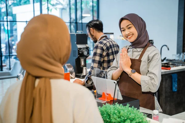 Asiático muçulmano café trabalhador acolhedor cliente em sua loja — Fotografia de Stock