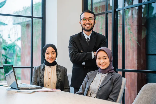 Homem de negócios sorridente e mulheres de negócios muçulmanas com encontro laptop no café — Fotografia de Stock